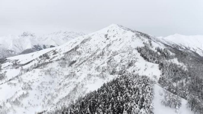 鸟瞰冷山顶冰雪旅游运动生态旅游山，山峰悬崖，岩石山脊，景观。冬季自然中无人驾驶飞机飞越山脉。慢动作