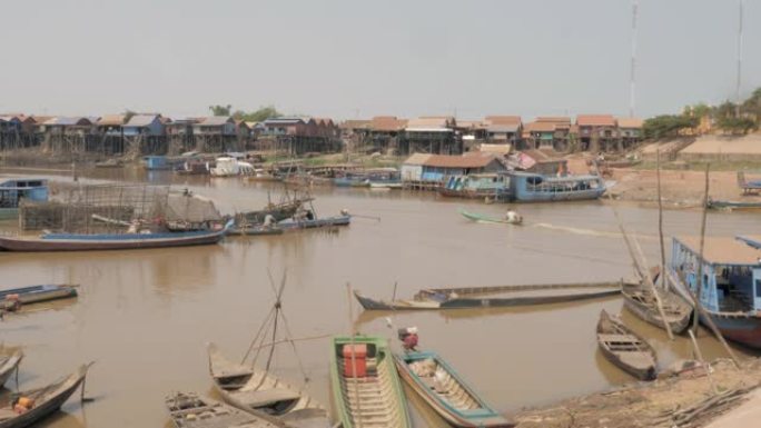长尾渔船驶过洞里萨河的一个浮动村庄