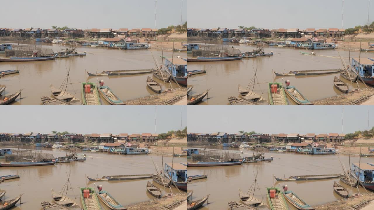 长尾渔船驶过洞里萨河的一个浮动村庄