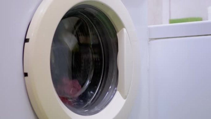 用家用洗衣机洗彩色衣服。旋转滚筒。4K