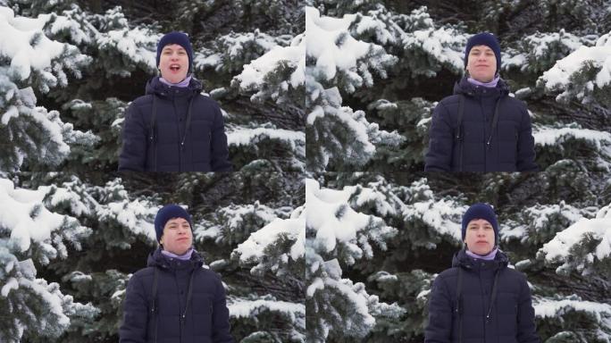 十几岁的男孩在冬天的森林里玩耍和吃雪，明亮的雪山枞树，美丽的大自然