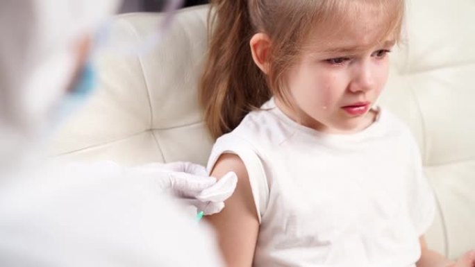 小女孩哭着受伤和害怕。医生打针。接种疫苗。