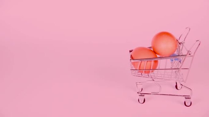 粉红色背景的迷你购物车中的棕色鸡蛋。