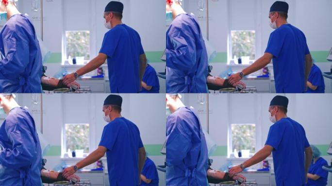 手术室的外科手术。男医生在门诊手术过程中控制病人的脉搏。外科医生的团队合作。