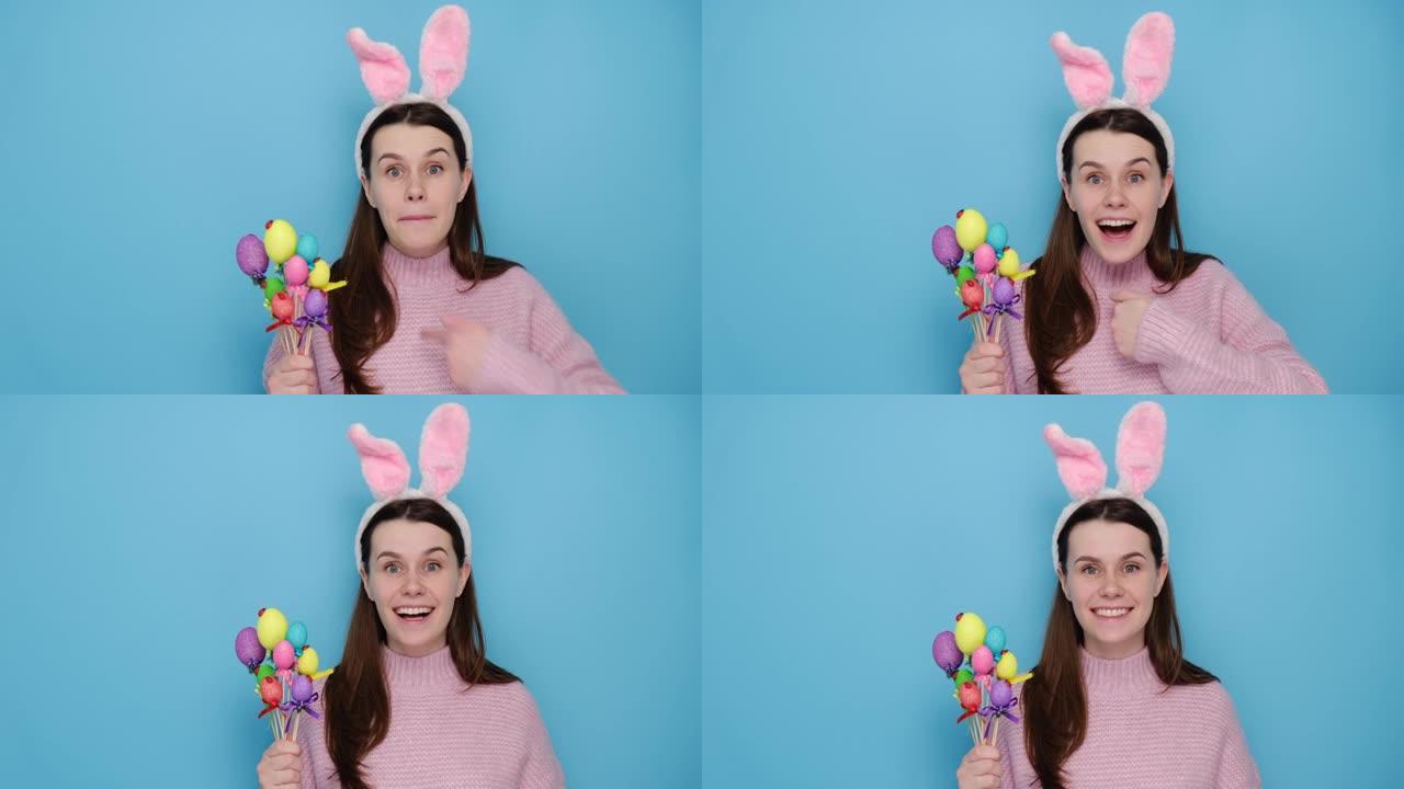 开朗惊讶的年轻女性在兔子蓬松的耳朵上有疑问的表情，问你是说我，背着小复活节彩蛋，穿着粉红色套头衫，孤