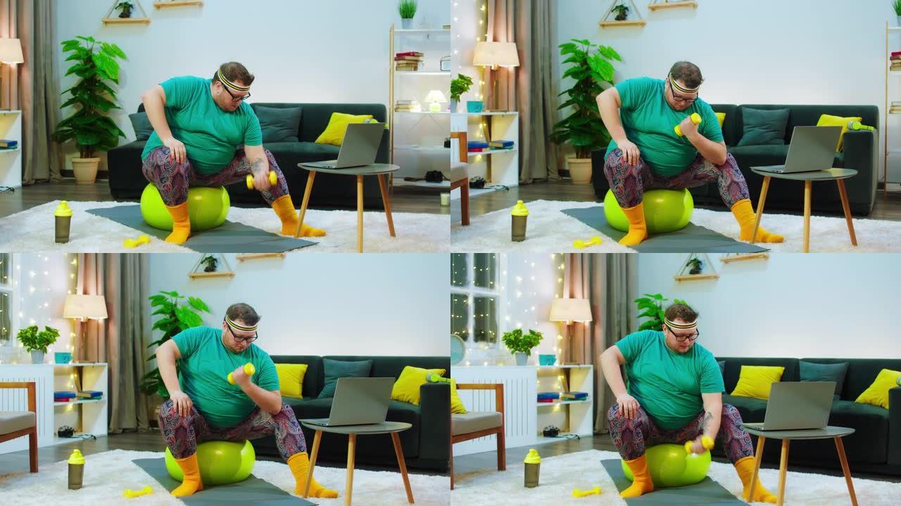 有一个戴着眼镜的肥胖男人，他留着胡须，坐在黄色的瑜伽球上，他非常担心用粪铃锻炼，他正在看着笔记本电脑