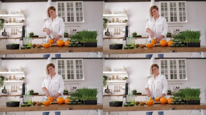 女人切橙子，放入搅拌机中搅打生态有机新鲜食品。