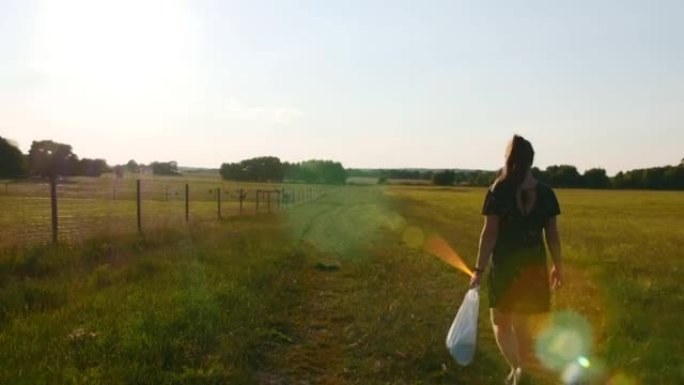 夏天，女孩去大农场喂鹿。日落时的风景。