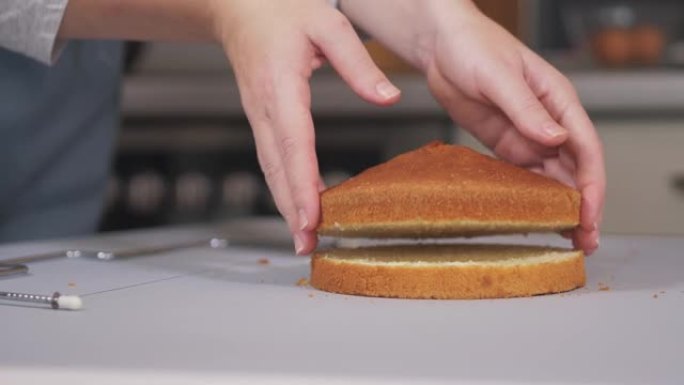 糕点师使用特殊的切刀将烤制的蛋糕切成均匀的层。