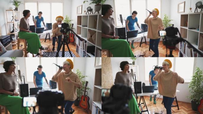 三位年轻艺术家在家庭音乐工作室用相机为他们的新歌录制视频
