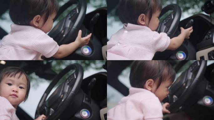 可爱的亚洲女性蹒跚学步坐在汽车驾驶员前排座位上玩方向盘童年的回忆和好奇心快乐快乐的孩子学习技巧经验纯
