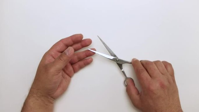 特写男性双手演示修指甲和理发用剪刀。