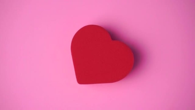 粉红色背景上的红色心脏。情人节，爱情，浪漫，婚礼概念。用心的最小艺术创意视频