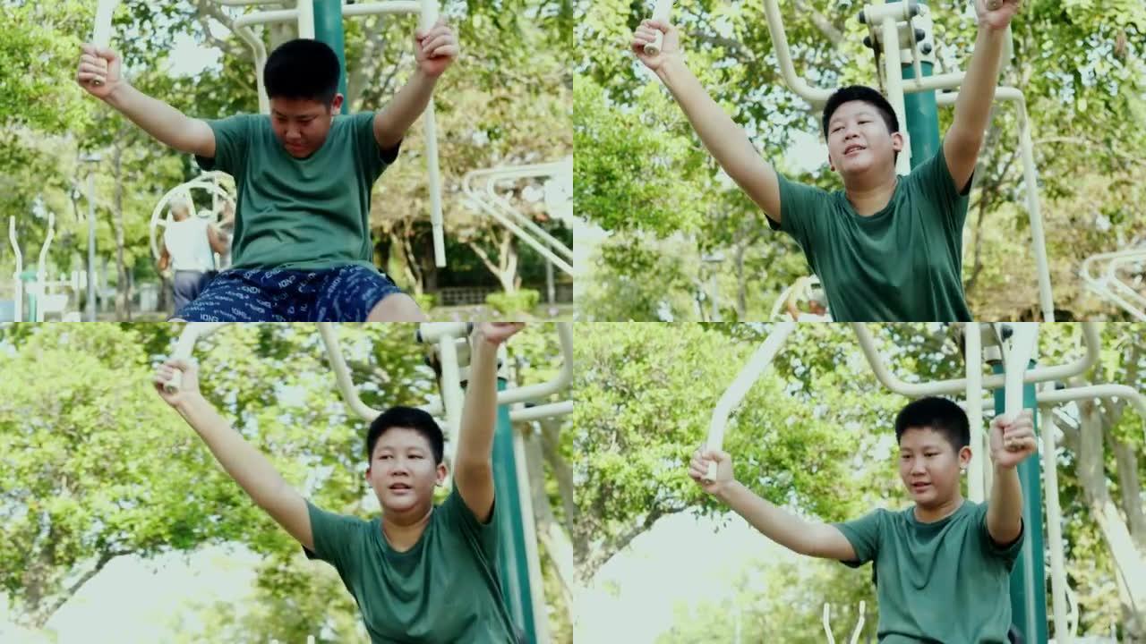 亚洲青春期男孩试图用户外运动器材在公园里用太阳光锻炼，生活方式概念。