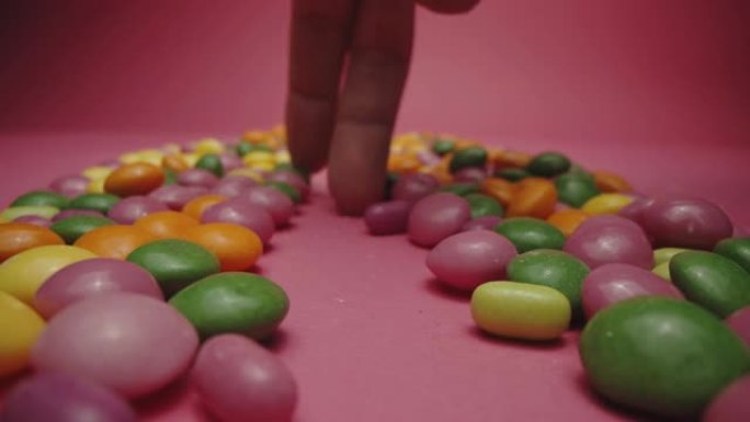人的手指在糖果周围走动