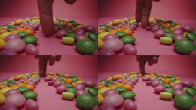 人的手指在糖果周围走动