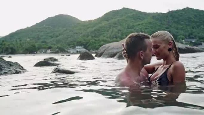 恋爱中的年轻夫妇在海中接吻