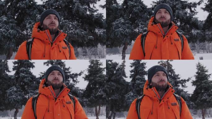 一名30多岁的成年白人男子在白雪覆盖的松树下走向相机
