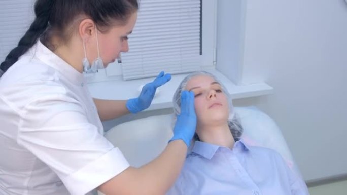 美容师在脸上注射生物evitalization后使用愈合霜。