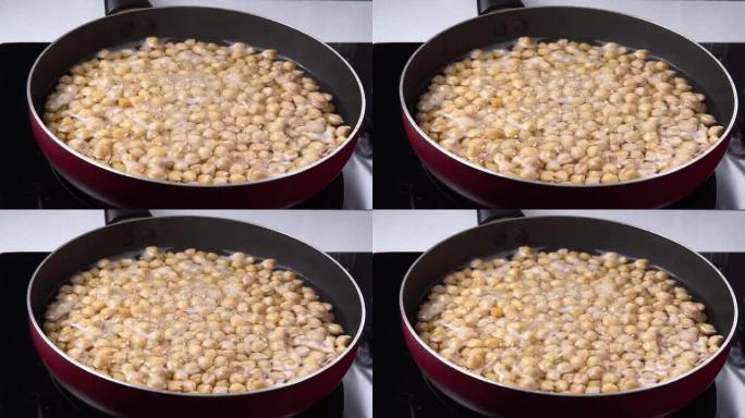 用热水煮鹰嘴豆。干鹰嘴豆浸没在水中。