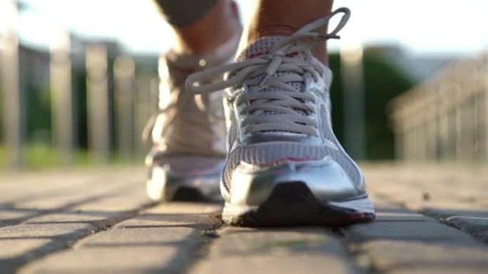灰色道路上年轻合身的女人双手系运动鞋鞋带
