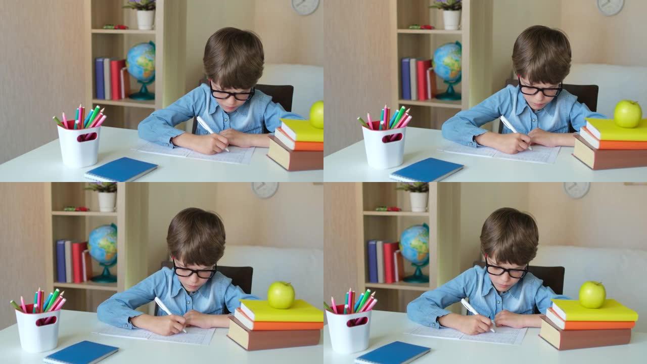 戴眼镜的小男孩小学生在厨房里学习写作业
