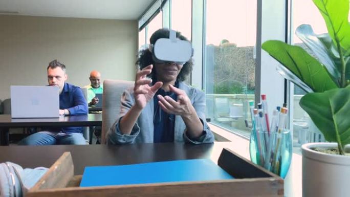 在创意技术公司工作的成熟女商人使用虚拟现实耳机进行业务和交流