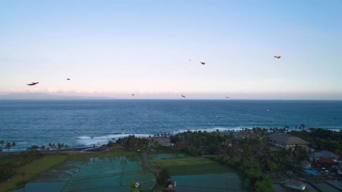 风筝在日落时在海洋附近飞翔鸟瞰图
