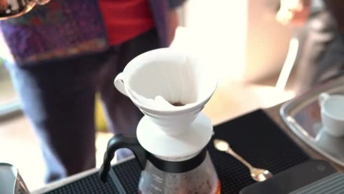 男人往咖啡里倒热水，蘸咖啡。