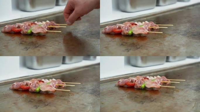 在餐厅厨房的热盘上烹饪的三个肉串的特写视图。在热盘上油炸肉和蔬菜串