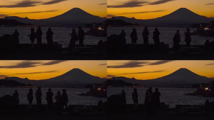 人们在拍照。从稻村加崎黄昏的富士山和江之岛