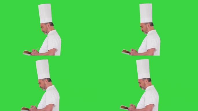 男厨师厨师在绿色屏幕上做笔记，色键