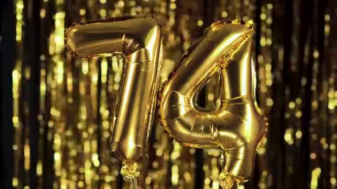 金色数字74 74是由黄色背景上的充气气球制成的。一组完整的数字。生日、周年纪念日、日期概念