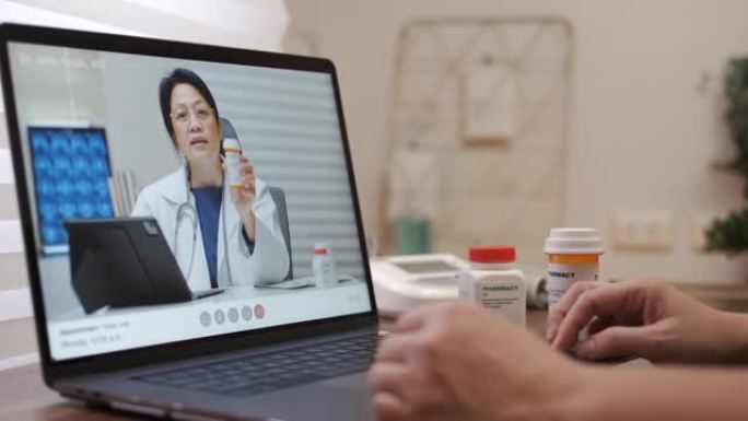 亚洲女性患者视频电话与她的医生要求处方使用平板电脑，而留在家里，患者有一个视频访问顾问关于她的病情。