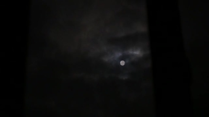 透过窗户看到满月。满月有云。