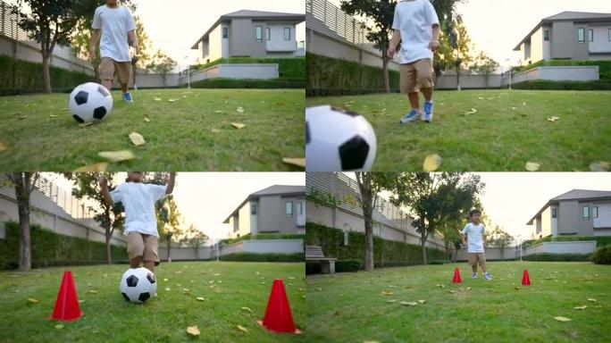 亚洲孩子在公园，房子的后院踢足球。度假和健康的概念
