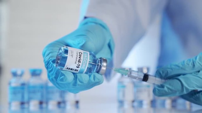 医生戴着手套，用注射器填充冠状病毒治疗疫苗，小瓶用冠状病毒疫苗开发，以防止新型冠状病毒肺炎。医疗保健