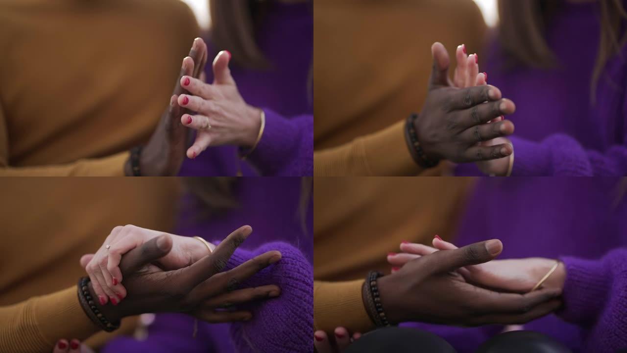 不同的手在一起。特写黑人和白人妇女手牵在一起