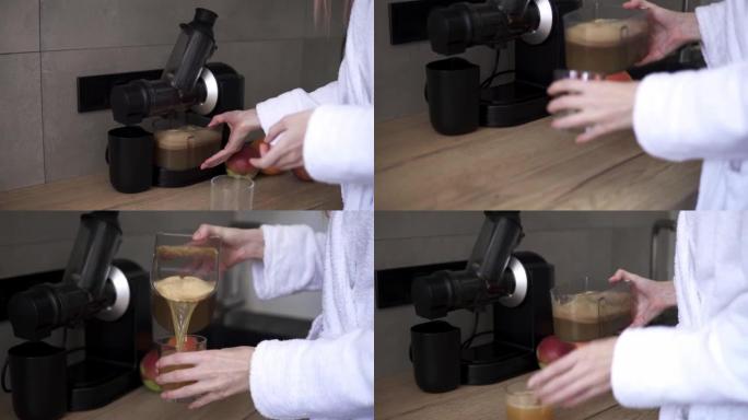 女人用榨汁机制作苹果汁，将新鲜果汁倒入玻璃杯中