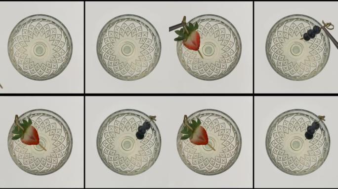 马提尼酒鸡尾酒杯的俯视图。用蓝莓和草莓装饰的酒精饮料。两个剪辑的分屏拼贴。孤立在白色背景上。