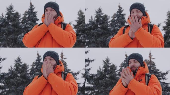 一名30多岁的男子在下雪的冬天，穿着一件鲜艳的橙色夹克，试图给他们热身。