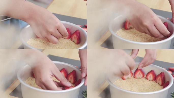 在家厨房烹饪和甜点用手切开的草莓片放在铝锅周围的特写镜头。底部有粗饼干粉