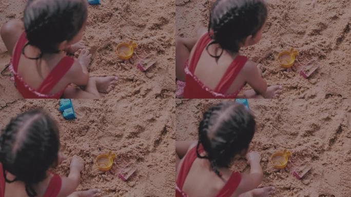 玩沙子和大海的小女孩