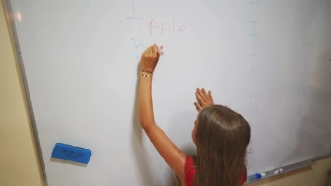 年轻的小学生在黑板上写答案