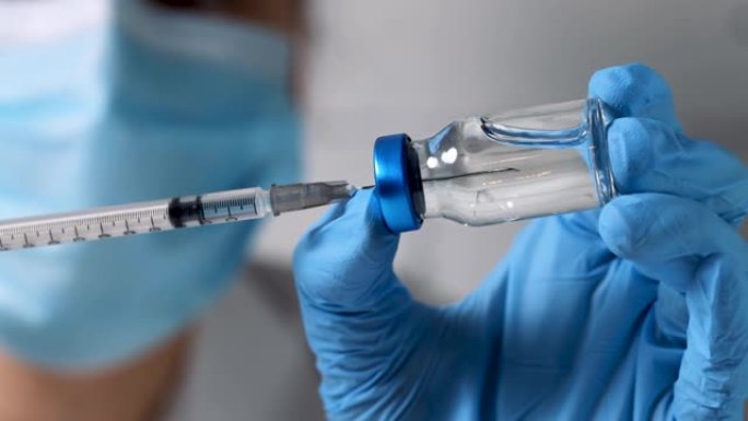 护士用疫苗填充注射器，用于从空白玻璃瓶中接种疫苗