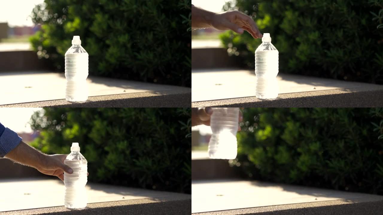 塑料饮水瓶凉水放在花园里，年轻人拿起喝。