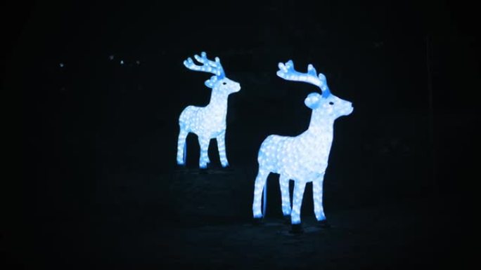 圣诞驯鹿，鹿。花环雕塑。圣诞花环灯。夜间户外照明驯鹿雕塑。照明夜城市街道上的圣诞装饰品