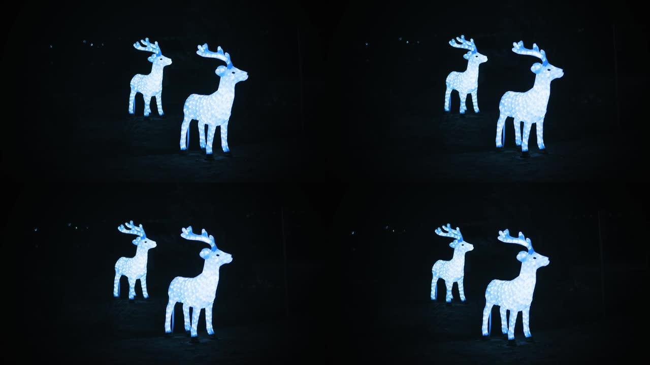 圣诞驯鹿，鹿。花环雕塑。圣诞花环灯。夜间户外照明驯鹿雕塑。照明夜城市街道上的圣诞装饰品