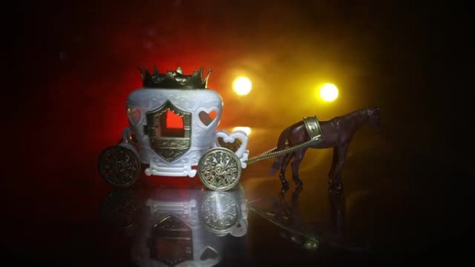 桌子上有微型马的小马车。深色雾状背景上的创意装饰。选择性聚焦