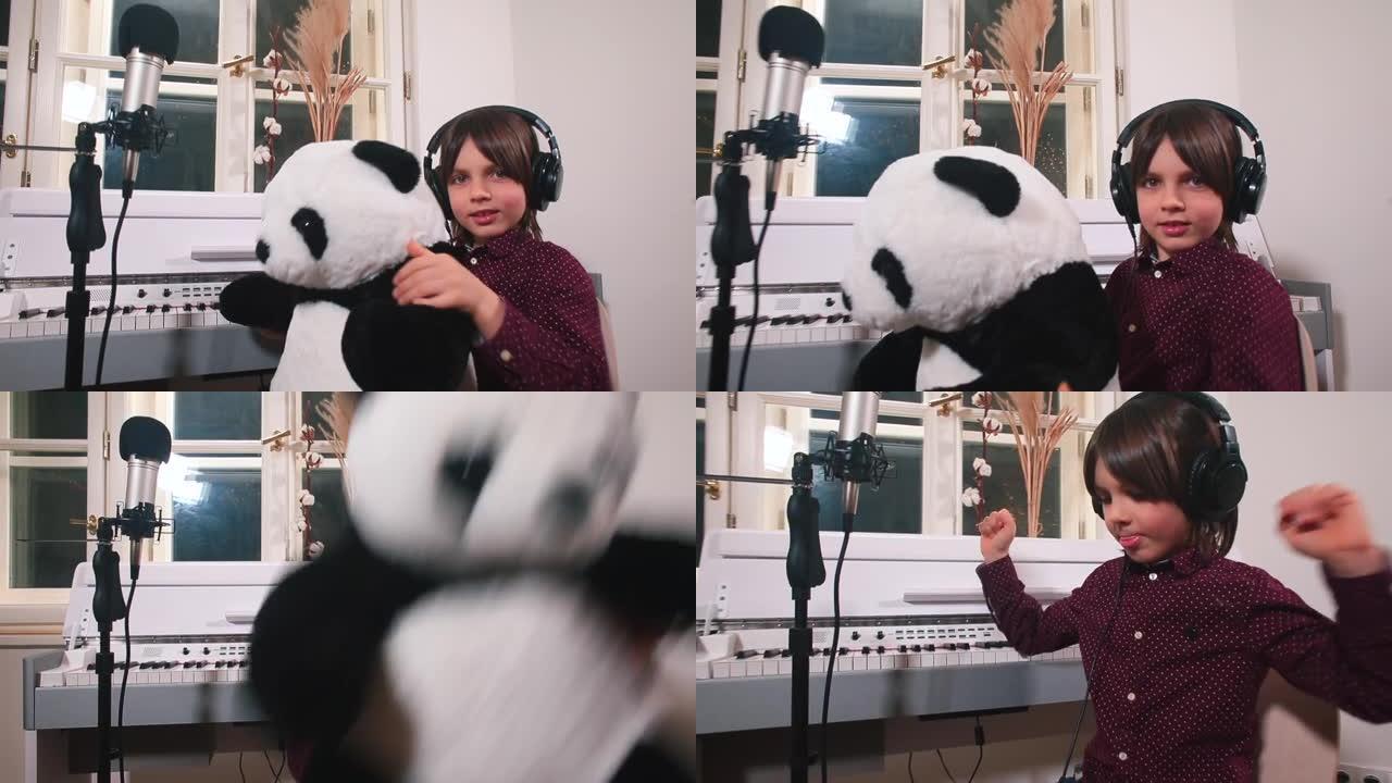 受启发的儿童耳机正在坐在前麦克风的工作室里跳舞的熊猫